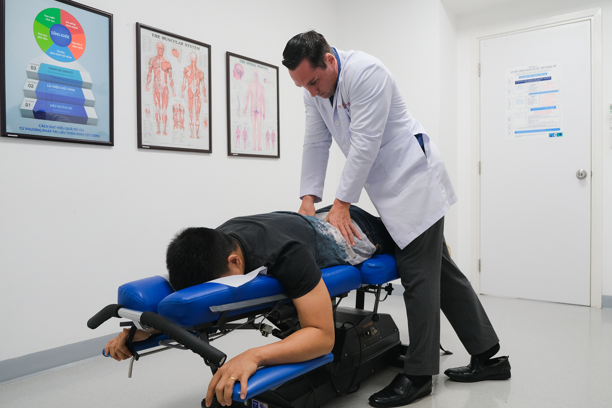 Bác sĩ Eric dùng phương pháp trị liệu thần kinh cột sống để điều trị đau lưng cho bệnh nhân (Ảnh: ACC).
